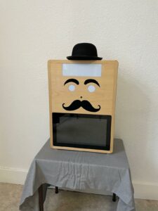 Photobooth Mister Moustache en bois, fabriqué artisanalement, avec chapeau et moustaches, vue de face